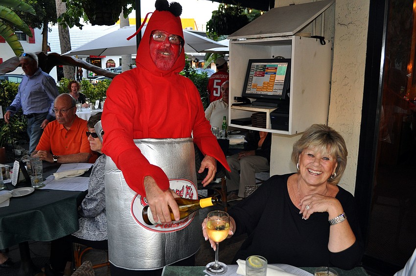 Doug Valtz pours wine for Anne Lunau Wednesday, Oct. 31, at Crab and Fin on St. Armands Circle.