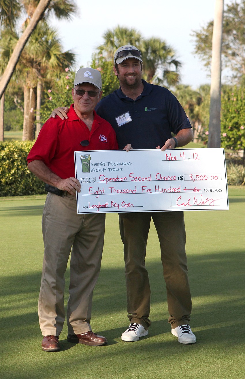 Ben Knisely of Operation Second Chance receives a check from Carl Wakely Sunday, Nov. 4, at the Longboat Key Club Islandside golf course. The tournament raised $8,500 for Operation Second Chance.