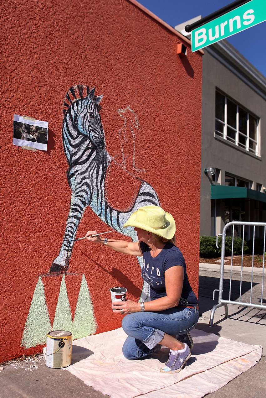 Francine Smetts does a vertical piece on the side of a building on the corner of Burns Court and Pineapple Ave.