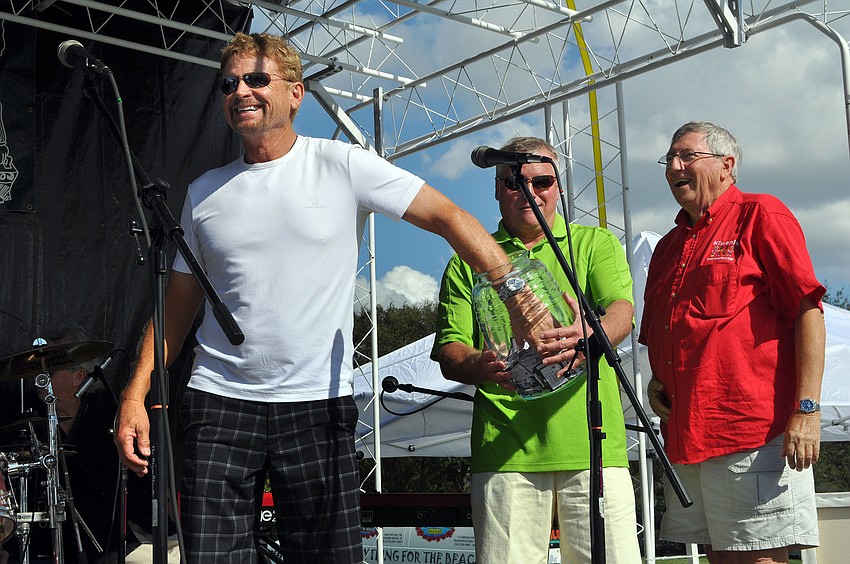 Jim Gettel puts his hand in the jar to pick the winning raffle ticket.