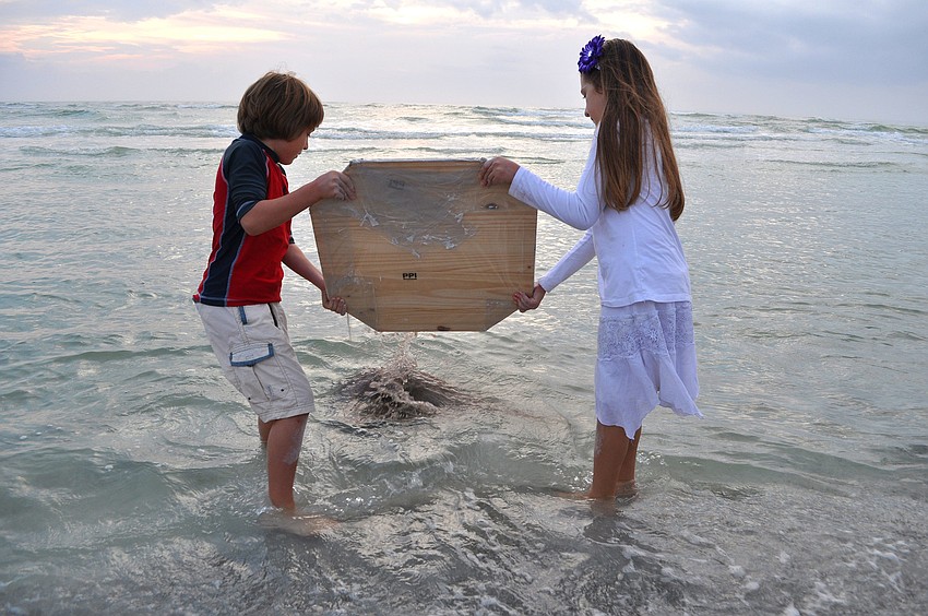 Gabriel and Ella Mirman dump the mixed sand into the Gulf of Mexico at the end of the ceremony.