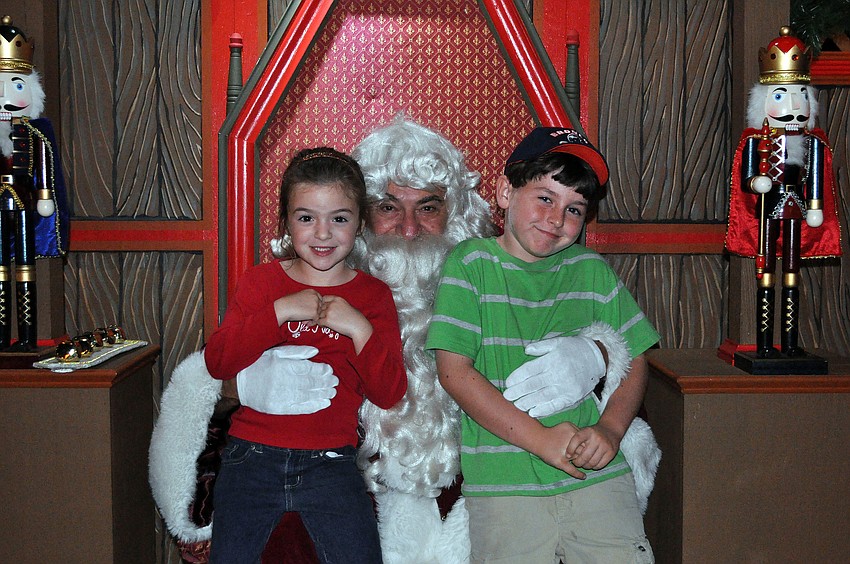 Lucie Perales, 5, and her brother Kique, 7, visit with Santa during Lights in Bloom Saturday, Dec. 15, at Marie Selby Botanical Gardens.
