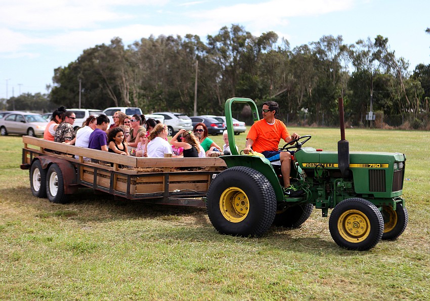 People piled into the back of a trailer bed to be driven around by a tractor Saturday, Oct. 27, at the Sarasota Pumpkin Festival.