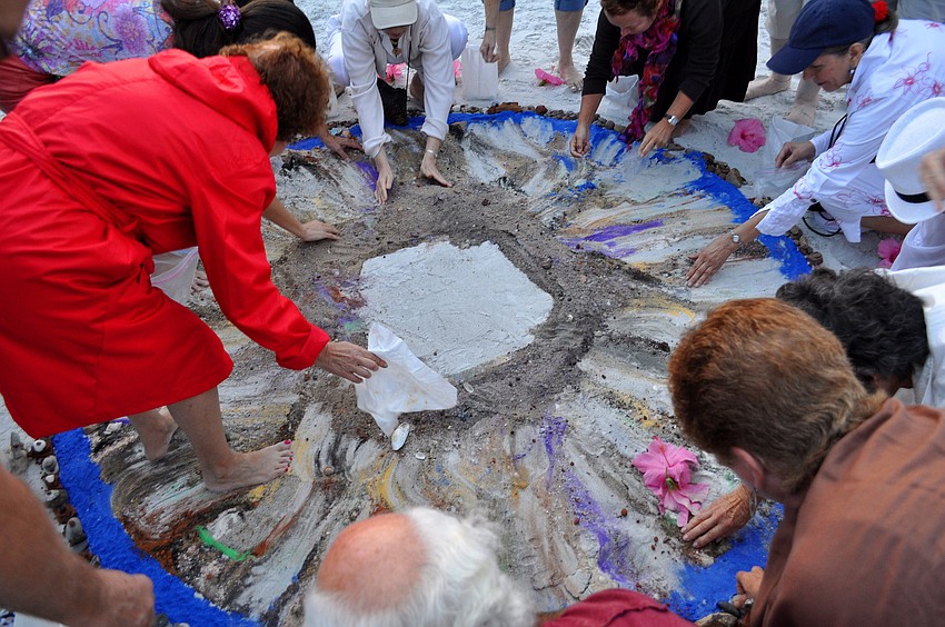 Following the ceremony, people were encouraged to take plastic bags and bowls to collect the mixed sand to take home.