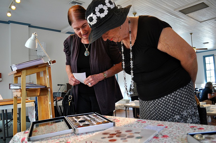 Maida Zamoff and Diane Hill look at some of the buttons on display.