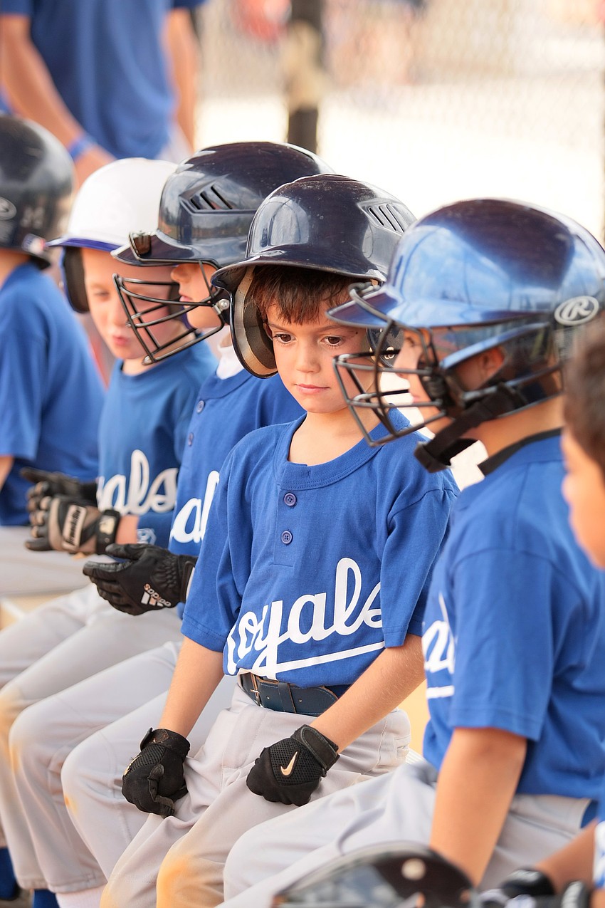 Jackson Watrobsky and his Royals teammates wait in the dugout for their turn to bat.