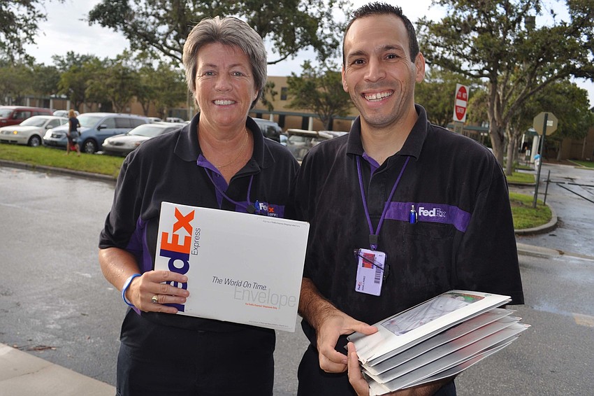 Marcia Burns and Hugo Perez handed out a package containing a coloring book, crayons and other rewards for students.