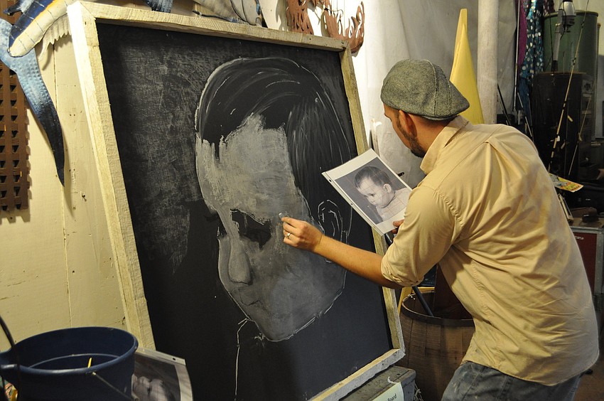 Truman Adams puts the finishing touches on a portrait of his son, Sky.