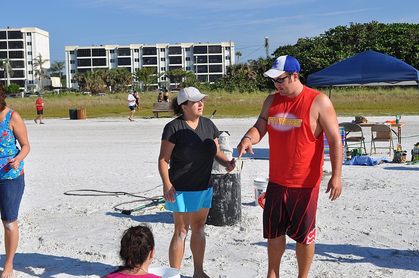 Adam Rhodus asks sand sculpting instructor Libby Bennett for some tips during a free, hands-on lesson.