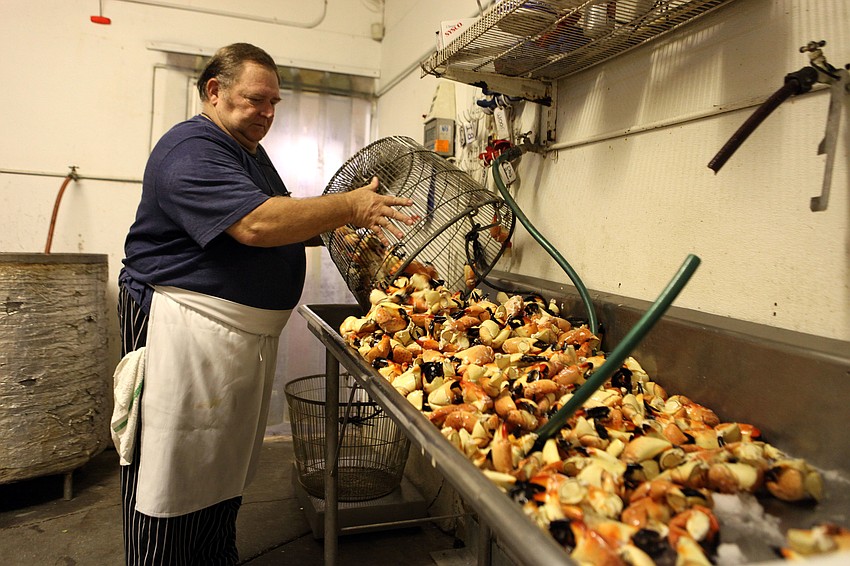 Robert Hicks dumps out 135 lbs. of stone crab Thursday, Oct. 18, in the kitchen of Moore's Stone Crab.