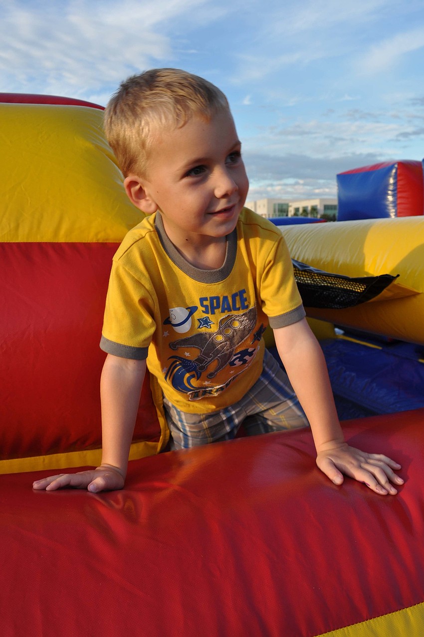 Enzo Knapp, 4, made his way through the inflatable obstacle course with the encouragement of his parents.