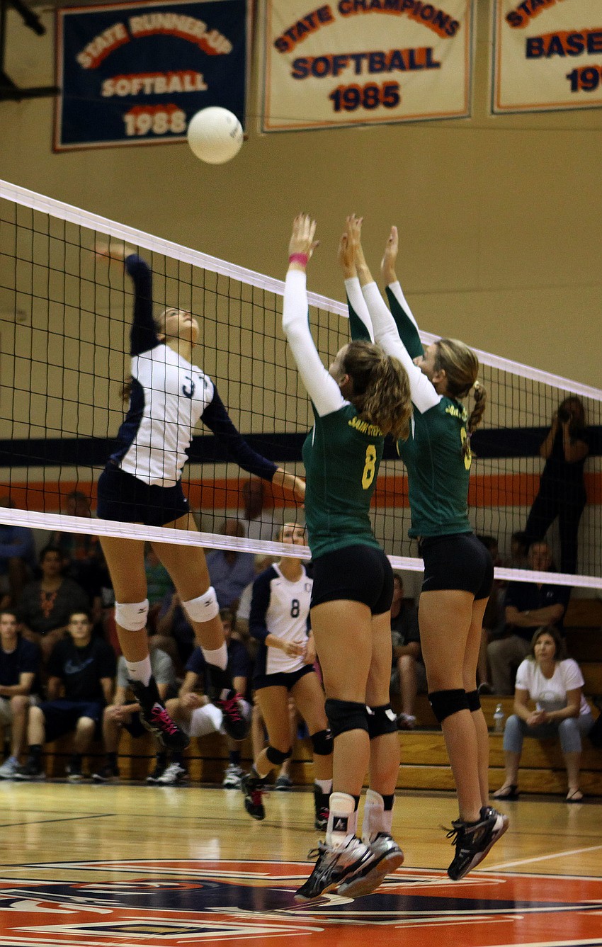 Gabriella Costa, No. 3, goes up to spike the ball at Tori Biach, No. 8, and Talia Barker, No. 3.