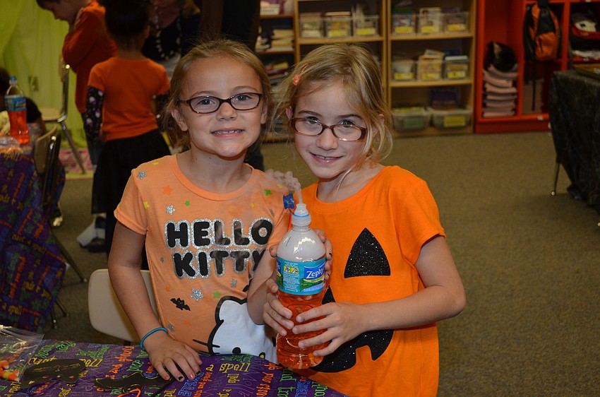 Kayla Desjardins and Cathlin Caldas hold a homemade 