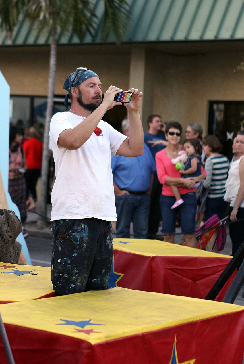 Truman Adams takes a photo on an iPhone of his 3D chalk piece Sunday, Nov. 4.