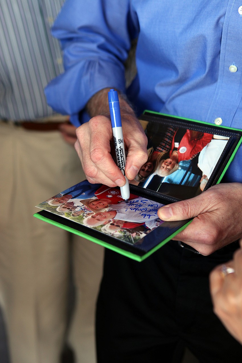 Gov. Rick Scott signs a photo of himself with Julie Brady Saturday, Nov. 3, at Dolphin Aviation.