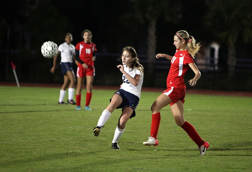 The Out-of-Door Academy's Katie Lang, No. 22, kicks the ball as Cardinal Mooneyâ€™s Sam Savinsky, No. 19, tries to stop her.