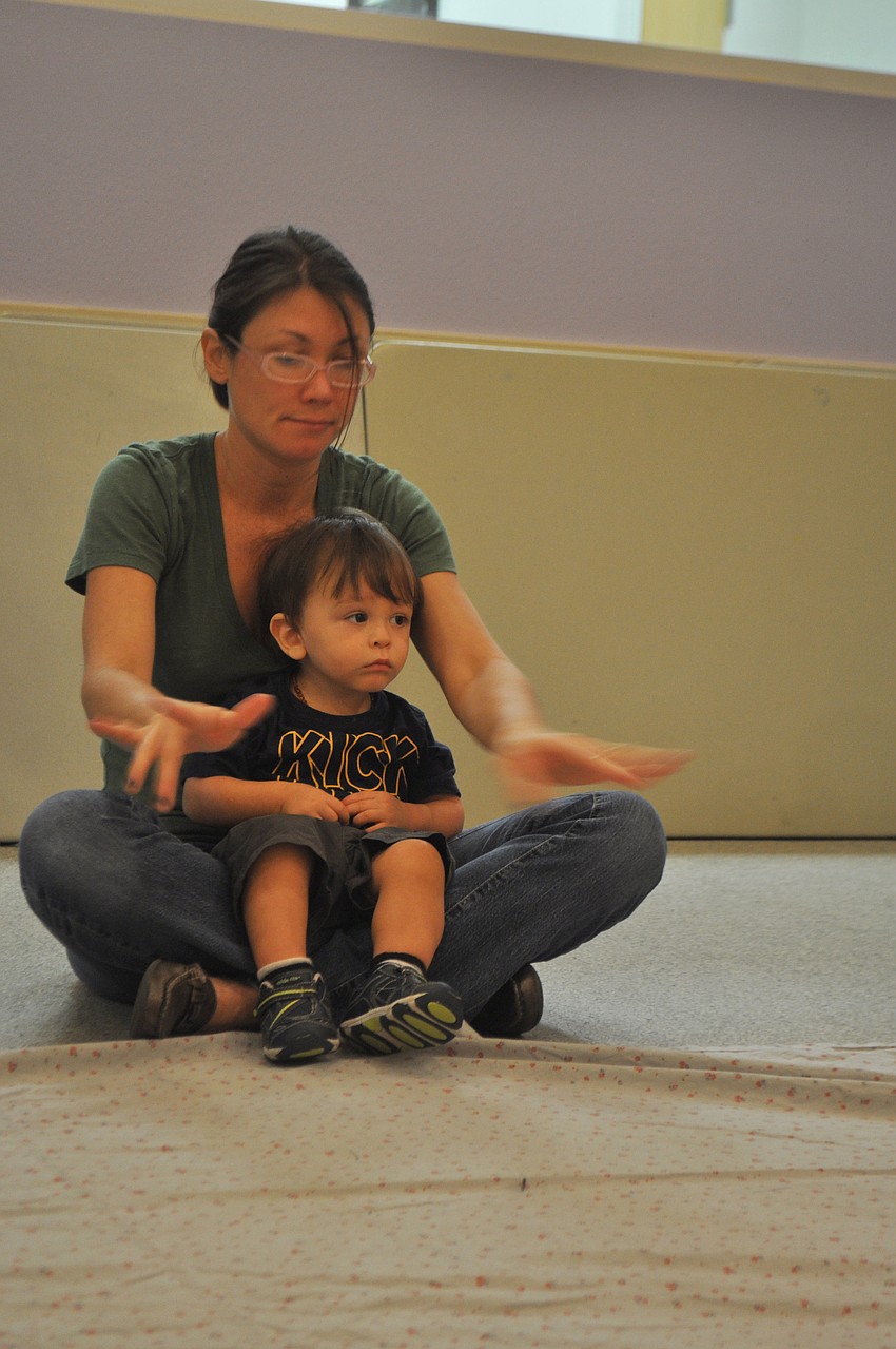 Emily Pinho holds her son Matthew, 16 months, as they listen to a story about winter and snow.