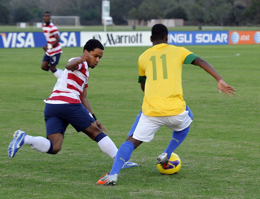 U.S. defender Elijah Martin tries to keep a Brazilian forward from advancing toward the goal.