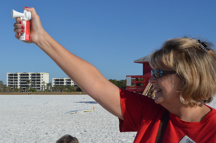 Pam Bell blasts the horn signaling the start of the 5K walk/run.