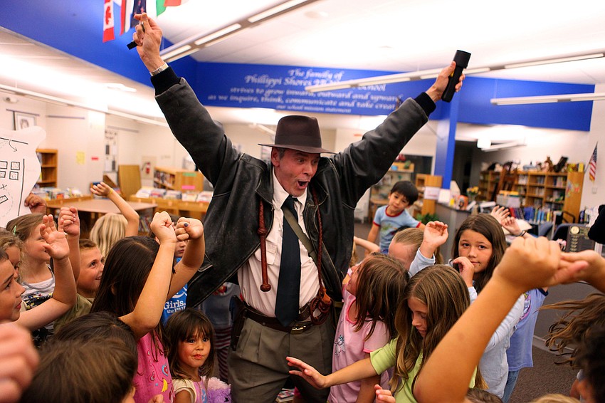 Michael Gange and the students cheer after finding the treasure during Phillippi Shoresâ€™ PJ and book reading night.