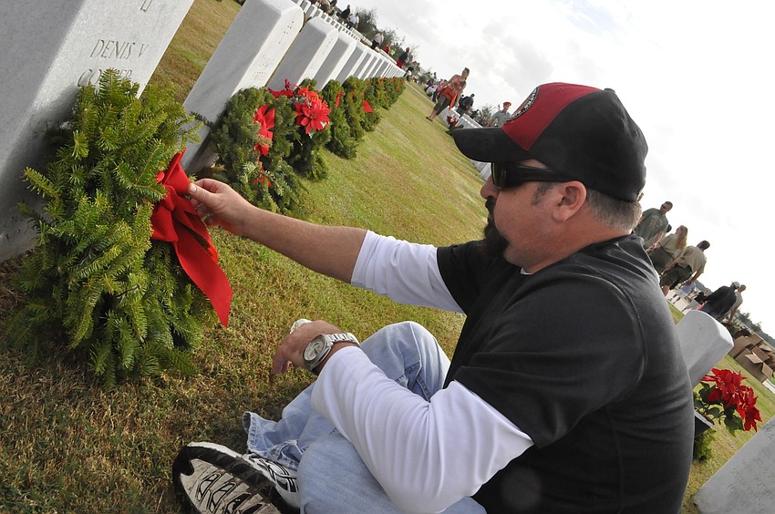 Maverick Johnson puts a wreath on Sergeant Denis V. Cooperâ€™s grave, his father.