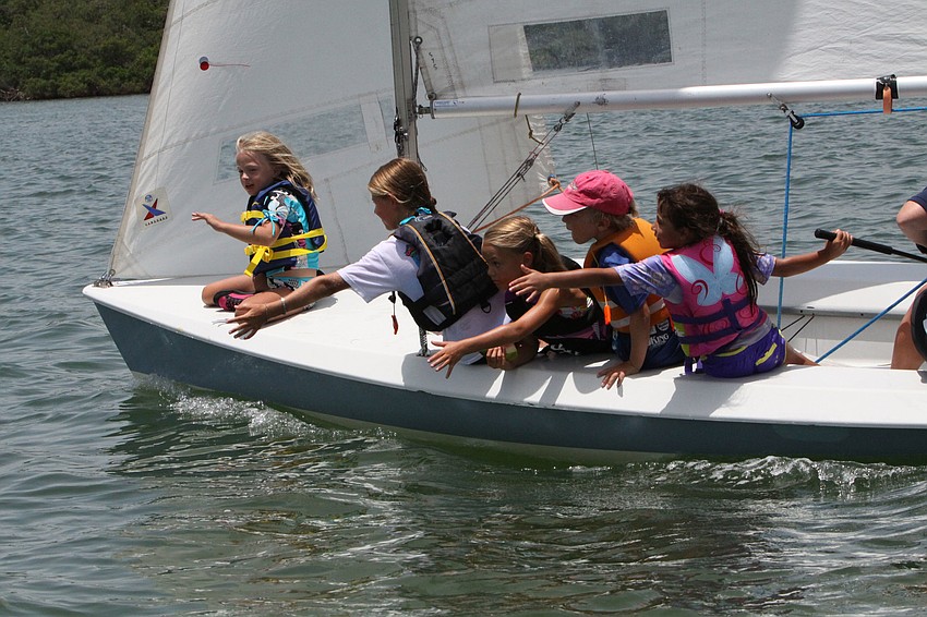Lilly Lazar, Lucy Dellosso, Mia Hanes, Owen Heinz and Hanah Wadud reached for a buoy July 27 at the Sarasota Youth Sailing programâ€™s summer camp.
