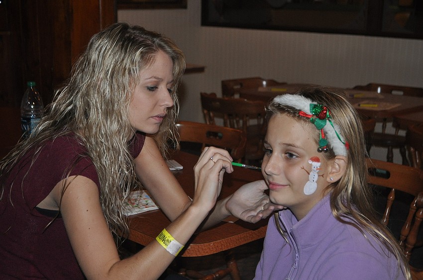 Sadge Moore paints snowmen on Rachel DeBickeroâ€™s face.