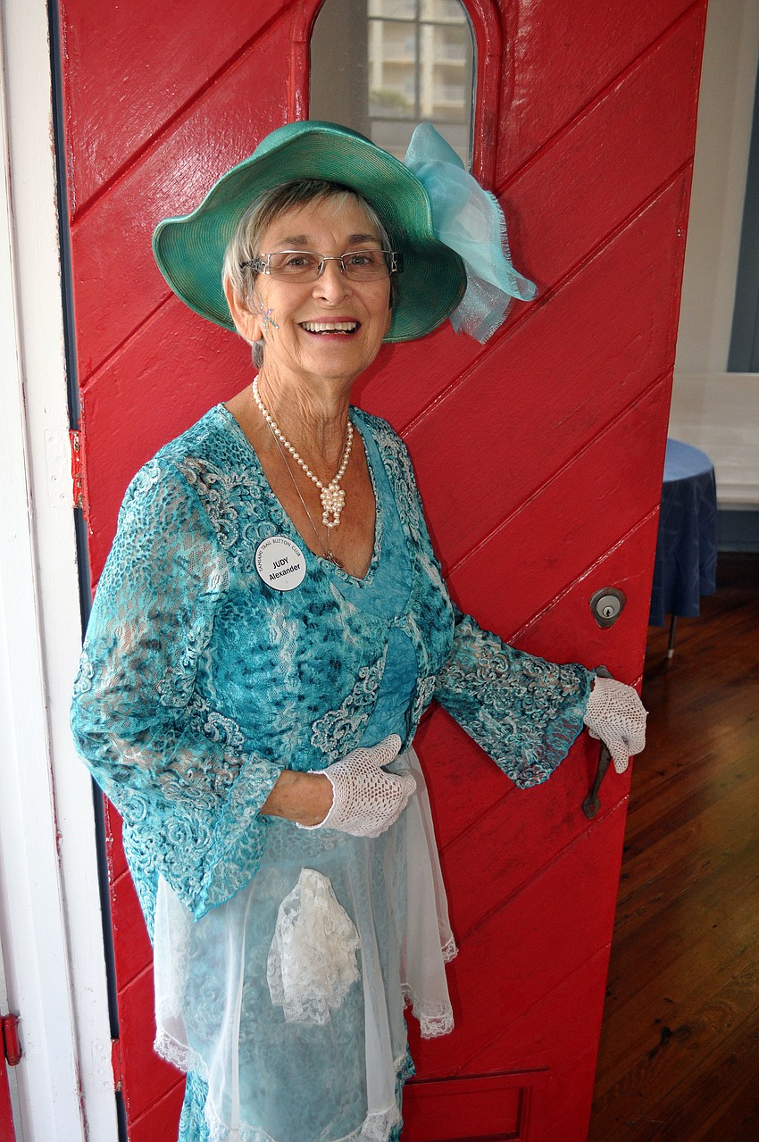 Judy Alexander, host, poses by the red door at the Crocker Memorial Church.
