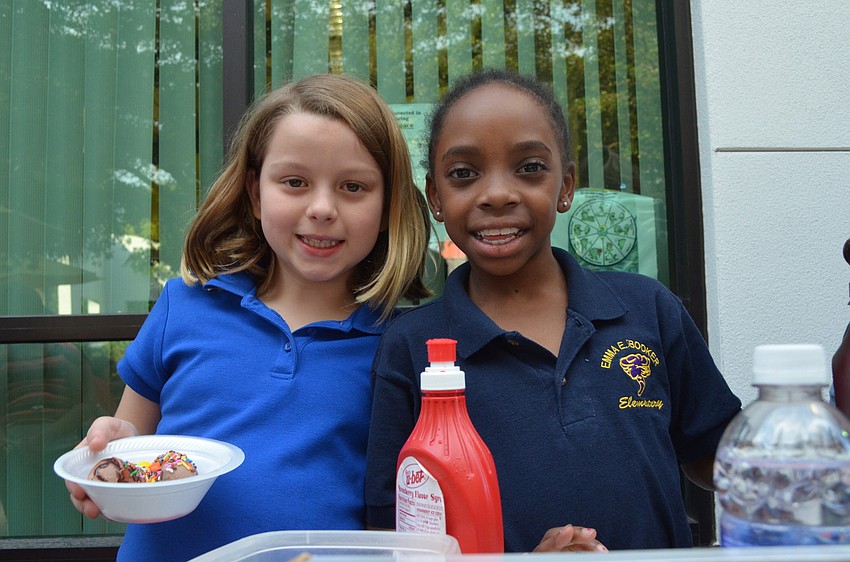 Hayley Ritter and Amarria Jones help put toppings on ice cream.