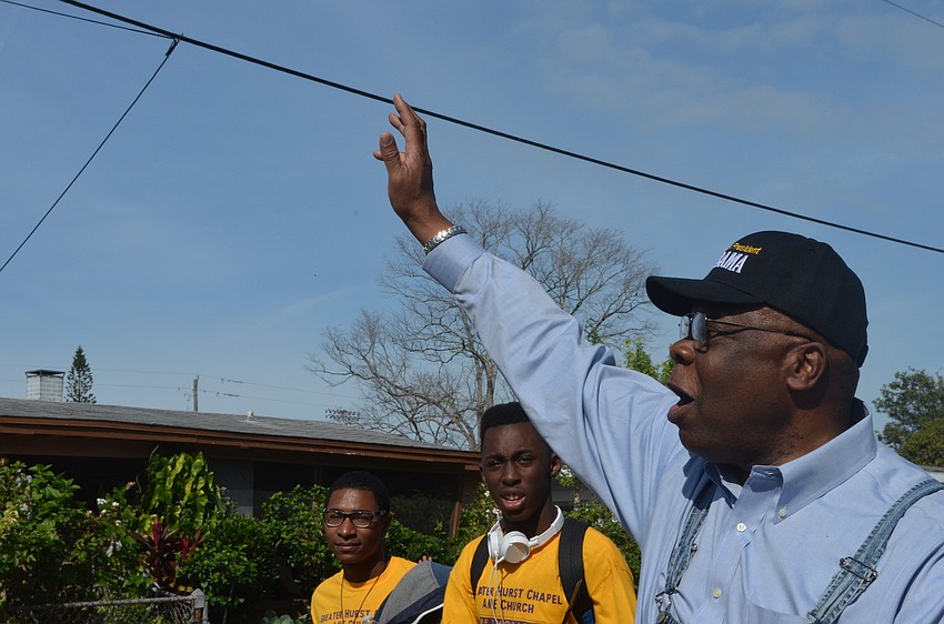 Vice Mayor Willie Charles waves hello to neighbors as he marches with community members.