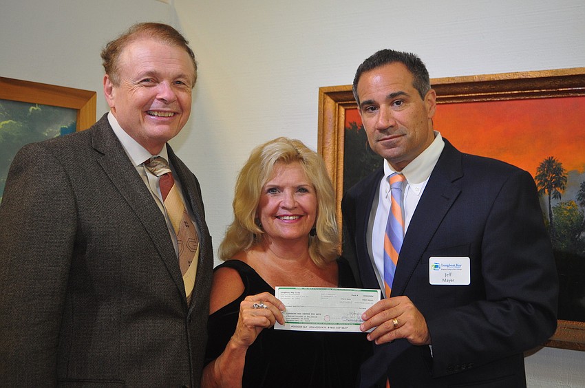 Longboat Key Club General Manager Jeff Mayers, far right, presents Larry Thompson and Jane Buckman a $10,000 donation for the Longboat Key Club Center for the Arts.