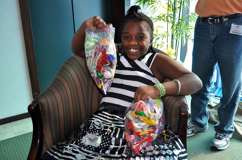 Kayla Williams, 8, shows off her bag of goodies and guards her friendâ€™s bag as well Wednesday, Oct. 31, during the Girls Inc. Trick-or-Treat outing.