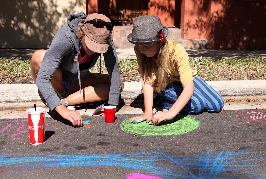Kristen Willis and her daughter, Taylor, 10, make their own chalk art Saturday, Nov. 3, on Selby Drive.