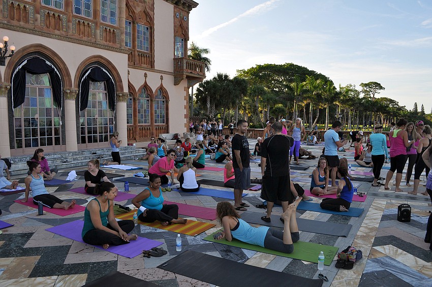 People mingle and set up their yoga mats Saturday, Sept. 15 behind the Ca d'Zan at the Ringling Museum of Art.