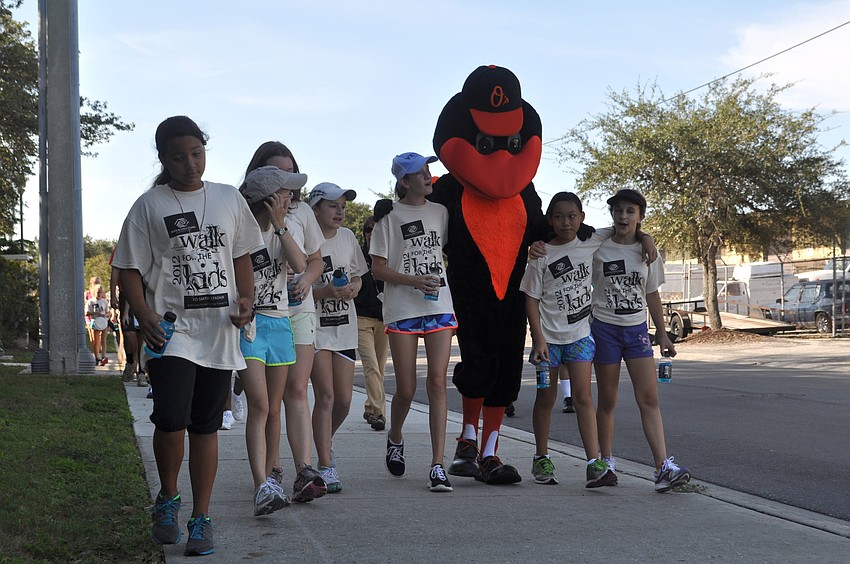 The Orioles mascot bird walks with children during the walk around Ed Smith Stadium.
