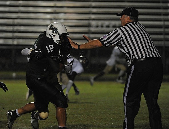 Lakewood Ranch junior running back Chris Pearcey fights to break past a Boca Ciega defender and a referee.