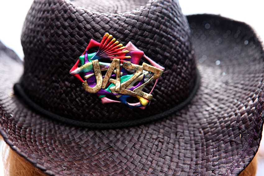 A woman wore a black cowboy hat with a colorful pin saying â€œJazzâ€.