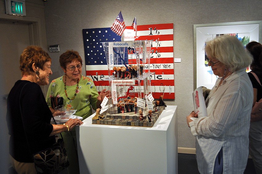 Shirley Foss, Sue Moreland and Marietta Lee have fun looking at Patricia Anderson Turnerâ€™s piece â€œAll American Vote Market Exchangeâ€.