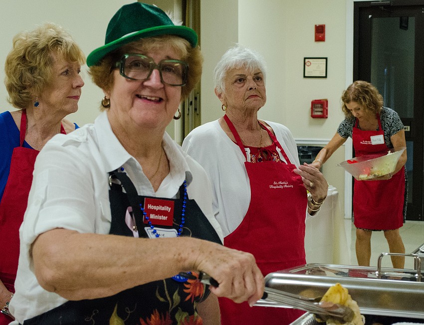 Mary Ann Turcotte serves brats during the celebration.