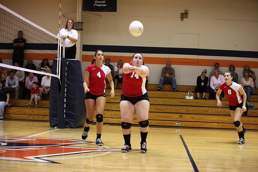 Lexi Barbour, No. 14, bumps the ball as teammates Kelly Firek, No. 4, and Maria Soscia, No. 8, prepare to come in and hit it over the net.