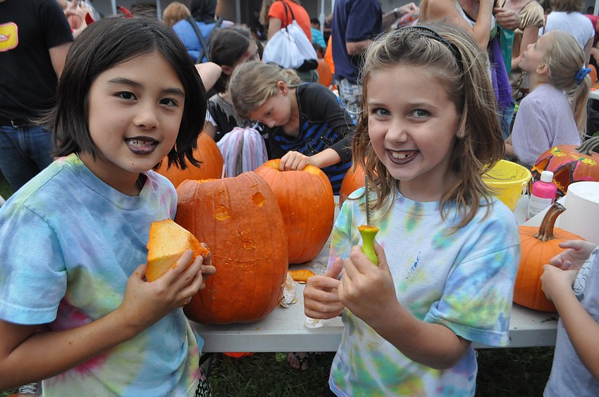 Avery Brum and Ella Emmett carve pumpkins.