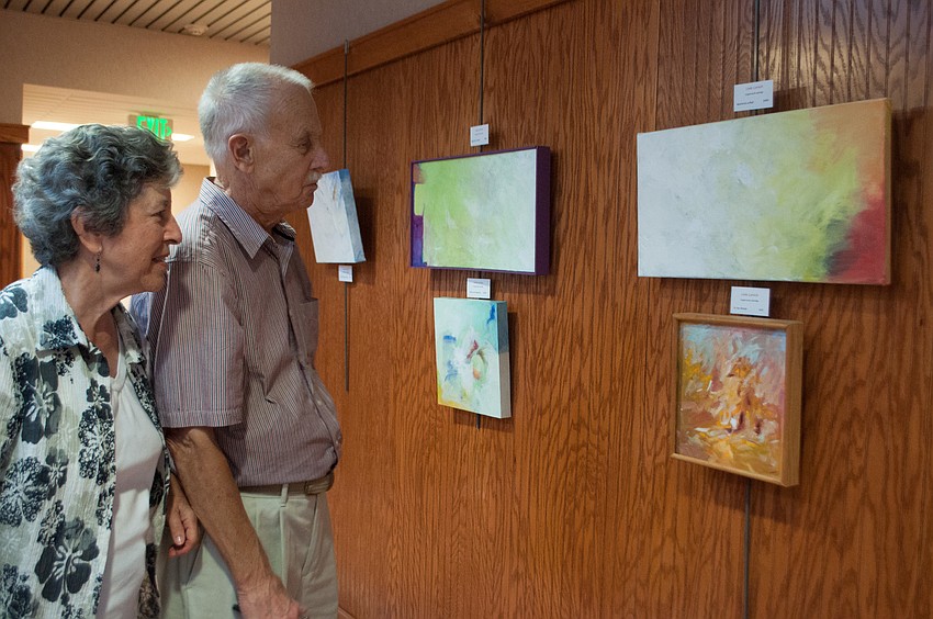Donna and Irv Brott gaze at paintings at the New Deal Gallery.