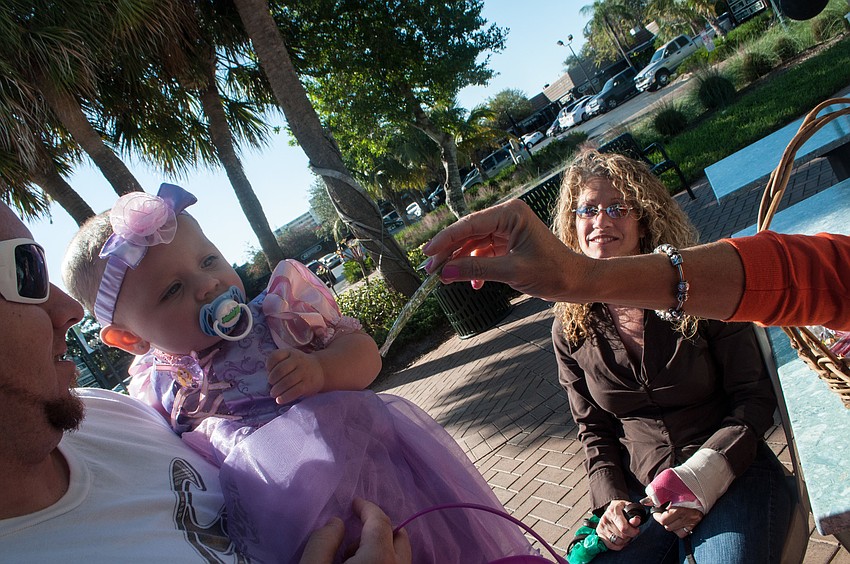 Kay Kouvatsos, co â€“owner of Village CafÃ©, gives candy to Serenity Carter.
