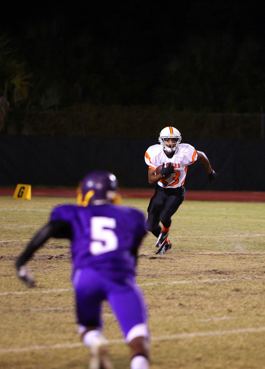 Rante Baker, No. 23, runs up the field with the ball.