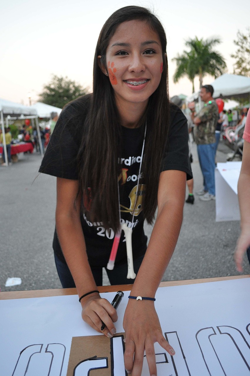 Elizabeth Velez, of Cardinal Mooney High School, finished a sign.