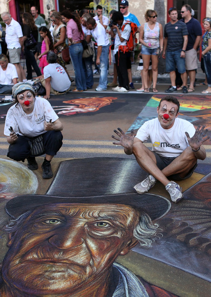 Vera Bugatti and Legno Luigi wear clown noses and show off their chalky hands as they pose with their piece Sunday, Nov. 4, during the Sarasota Chalk Festival.