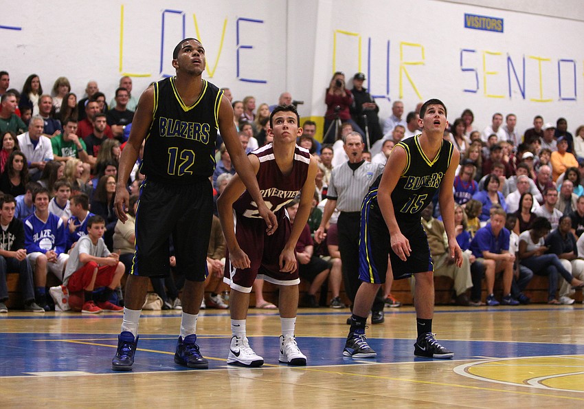 Sean Carrigan, No. 12, Josh Beychok, No. 20, and Joshua Yoder, No. 15, prepare to get the rebound after a foul shot.