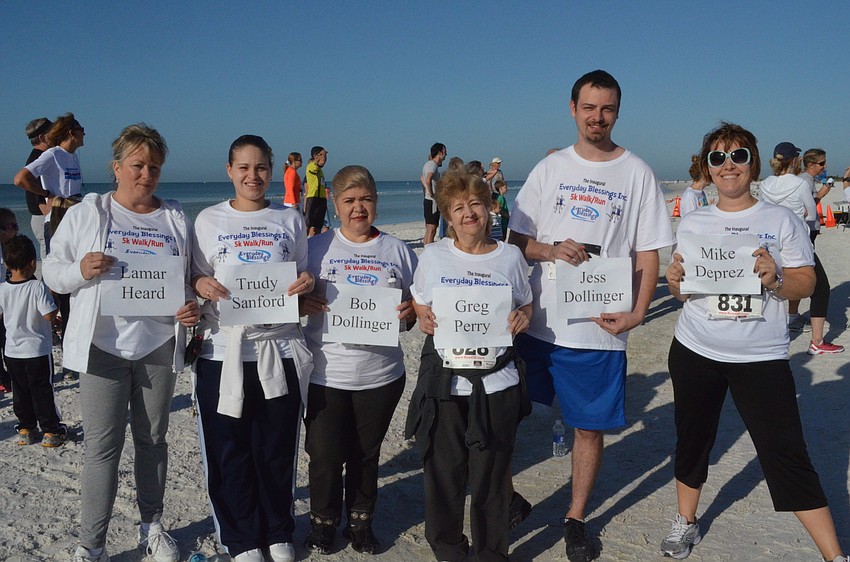 Tammy Dixon, Gina Vasquez, Lourdes Blandon, Maria Salazar, Matt Berry and Katya Sljusar hold signs with names of those who could not make the race.