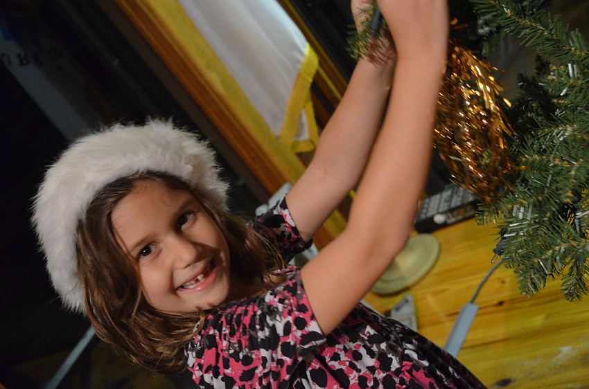 Chloe Johnson decorates the Christmas tree.