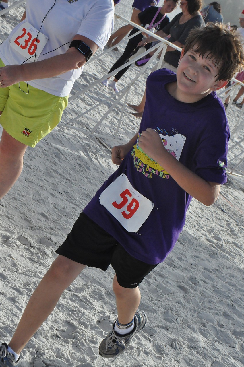Duncan DeVito, 12, finishes the race with a smile on his face.